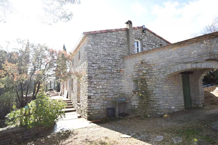 Façade extérieure d’un mas en pierre en cours de rénovation énergétique dans l’Hérault.
